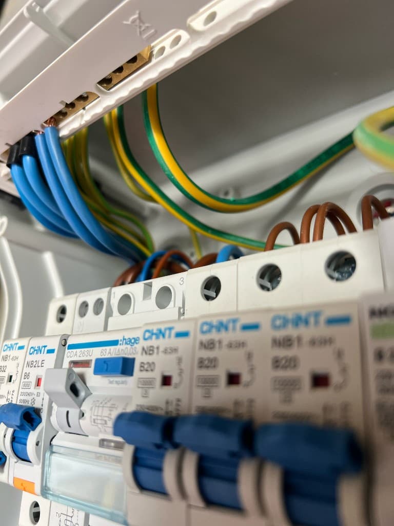 Professional electrician working on modern consumer unit – Fennor Developments